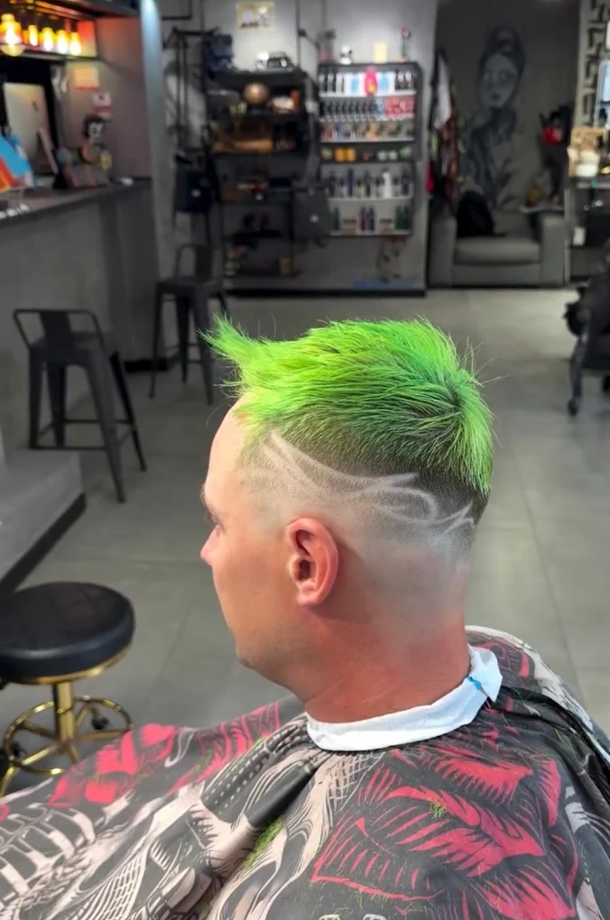 Mohicano con degradado y dibujo a navaja teñido de verde
