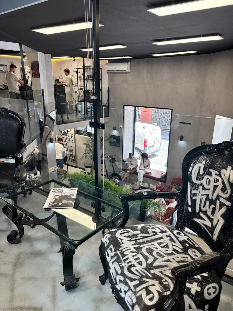 Zona de espera con sillones pintados a mano y altillo acristalado